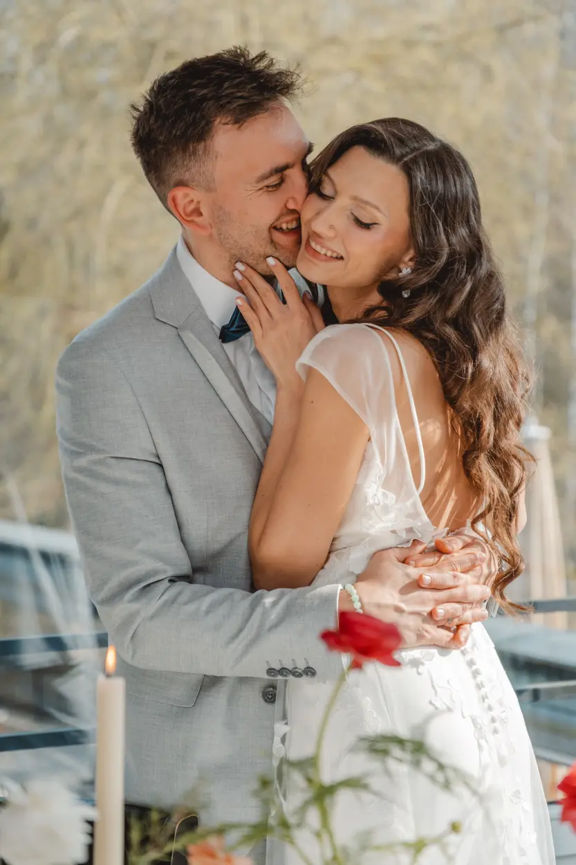Glückliches Brautpaar in inniger, natürlicher Umarmung im Freien während der Hochzeit